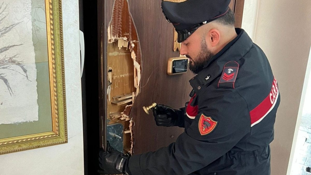 I carabinieri con la porta dell’appartamento semidistrutta