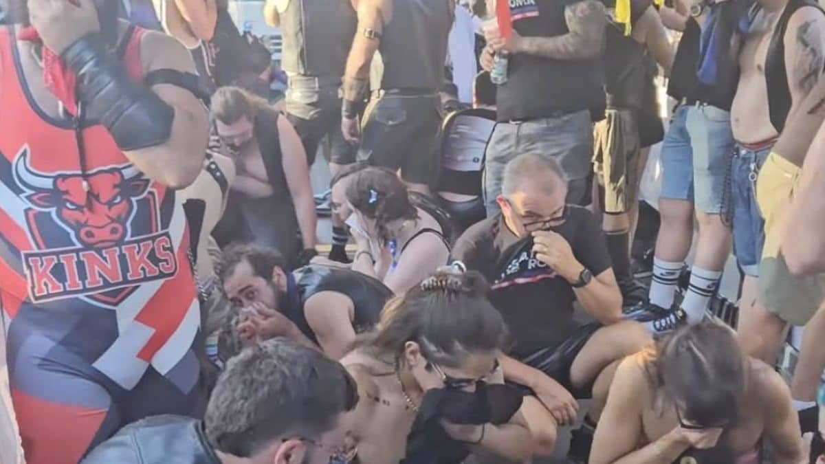 Manifestanti sul carro di Gender X si coprono la bocca con fazzoletti bagnati