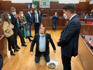 Il consigliere Michele Usuelli in ginocchio nell’aula del Consiglio regionale (Foto MiaNews)