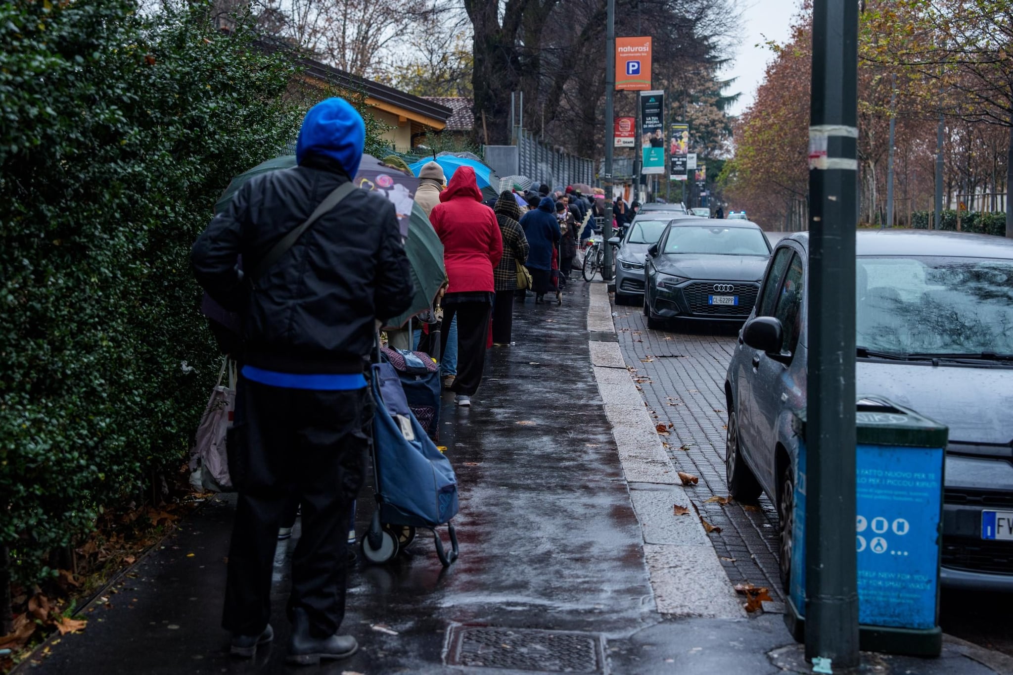 La coda di persone in attesa di ritirare un pacco alimentare fuori dalla sede di Pane Quotidiano a Milano