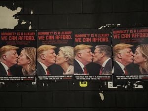 Al Fuorisalone di Milano spuntano manifesti di Trump che bacia Meloni e Netanyahu: “Leader costretti all’intimità”