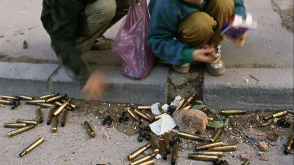 Due bambini raccolgono i bossoli di mitragliatrice per le strade di Sarajevo. (Foto da Getty Images)