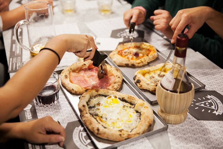 Pizze servite al tavolo di Briscola