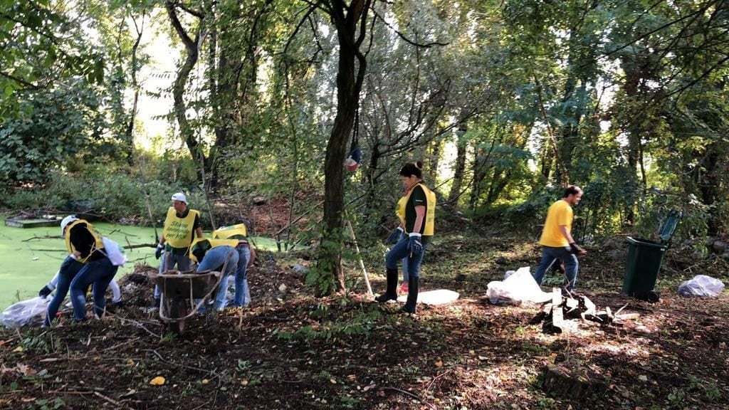 I dipendenti di Heineken Italia e i volontari di Legambiente al lavoro per ripulire il parco di Rogoredo