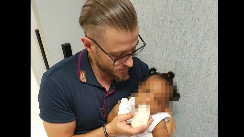Il poliziotto e la bambina, nello scatto diffuso dalla Questura di Napoli.