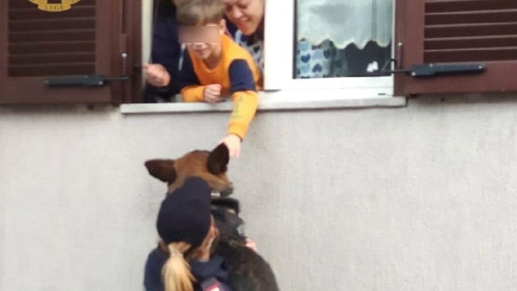 La poliziotta Chiara solleva Zorro, per la gioia del piccolo Emanuele.