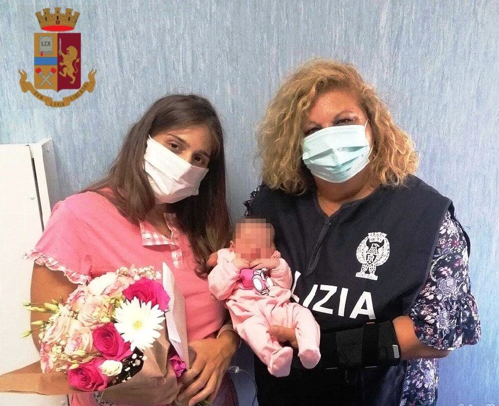 La donna dopo il parto assieme ad una poliziotta.