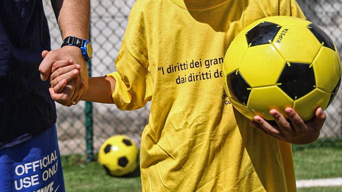 Padre e figlio si tengono per mano prima della partita.
