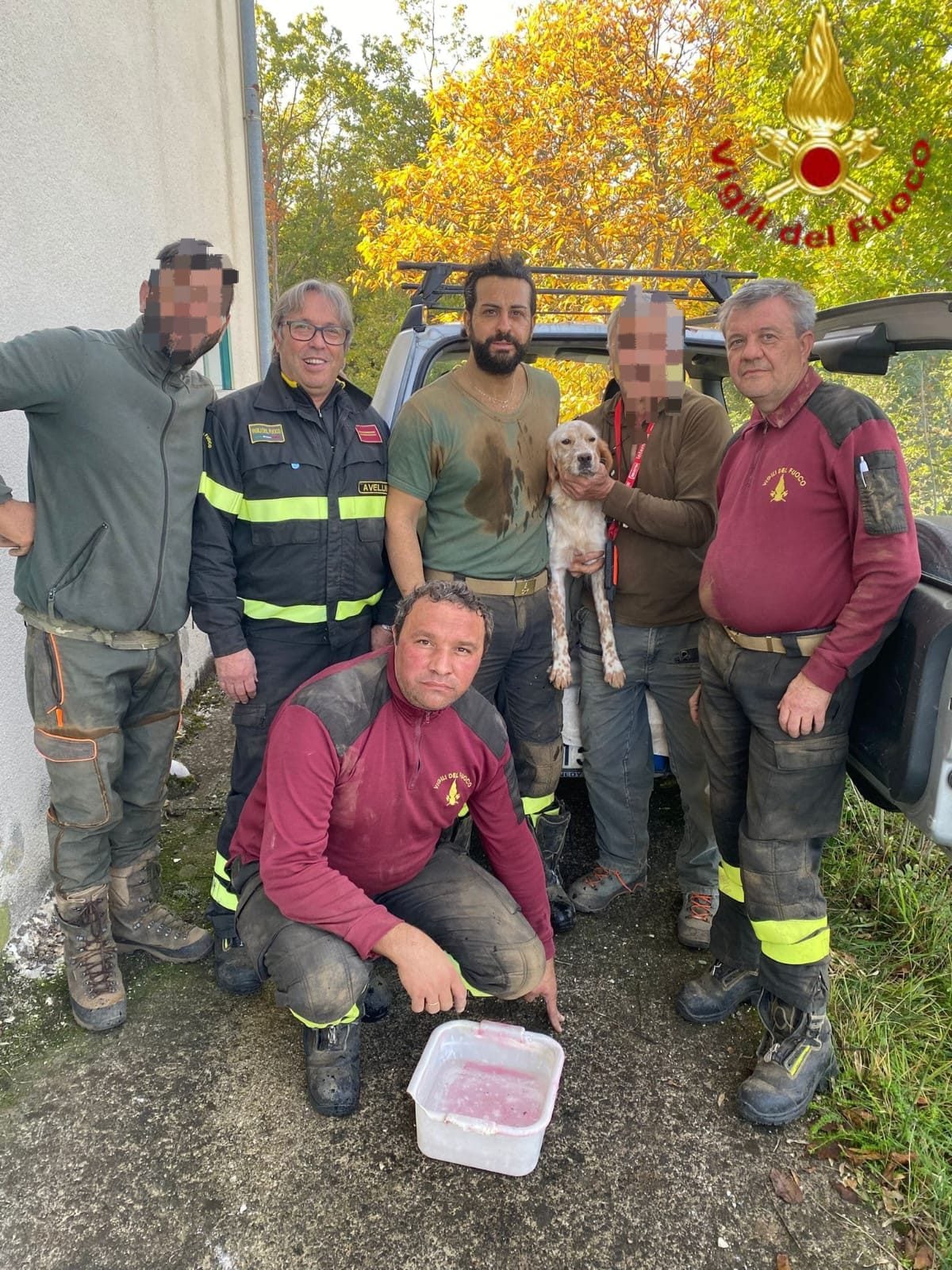 Il cane salvato e riaffidato ai proprietari, in posa assieme ai vigili del fuoco
