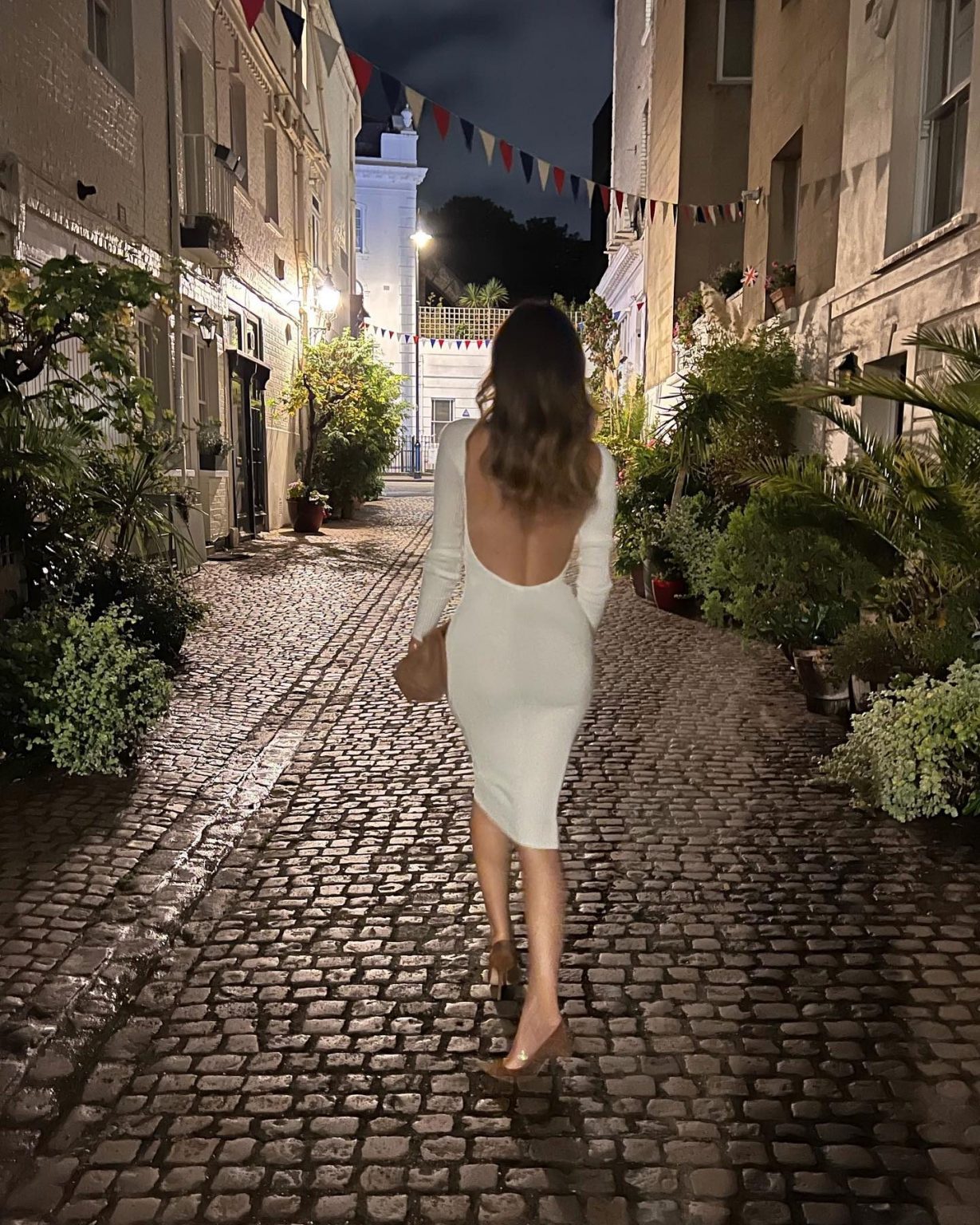 Alessia Marcuzzi in bianco con la schiena nuda per l'estate segue il