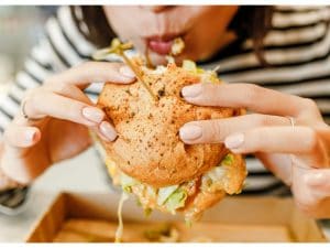 donna-che-mangia-hamburger-troppa-fame-300x225.jpg