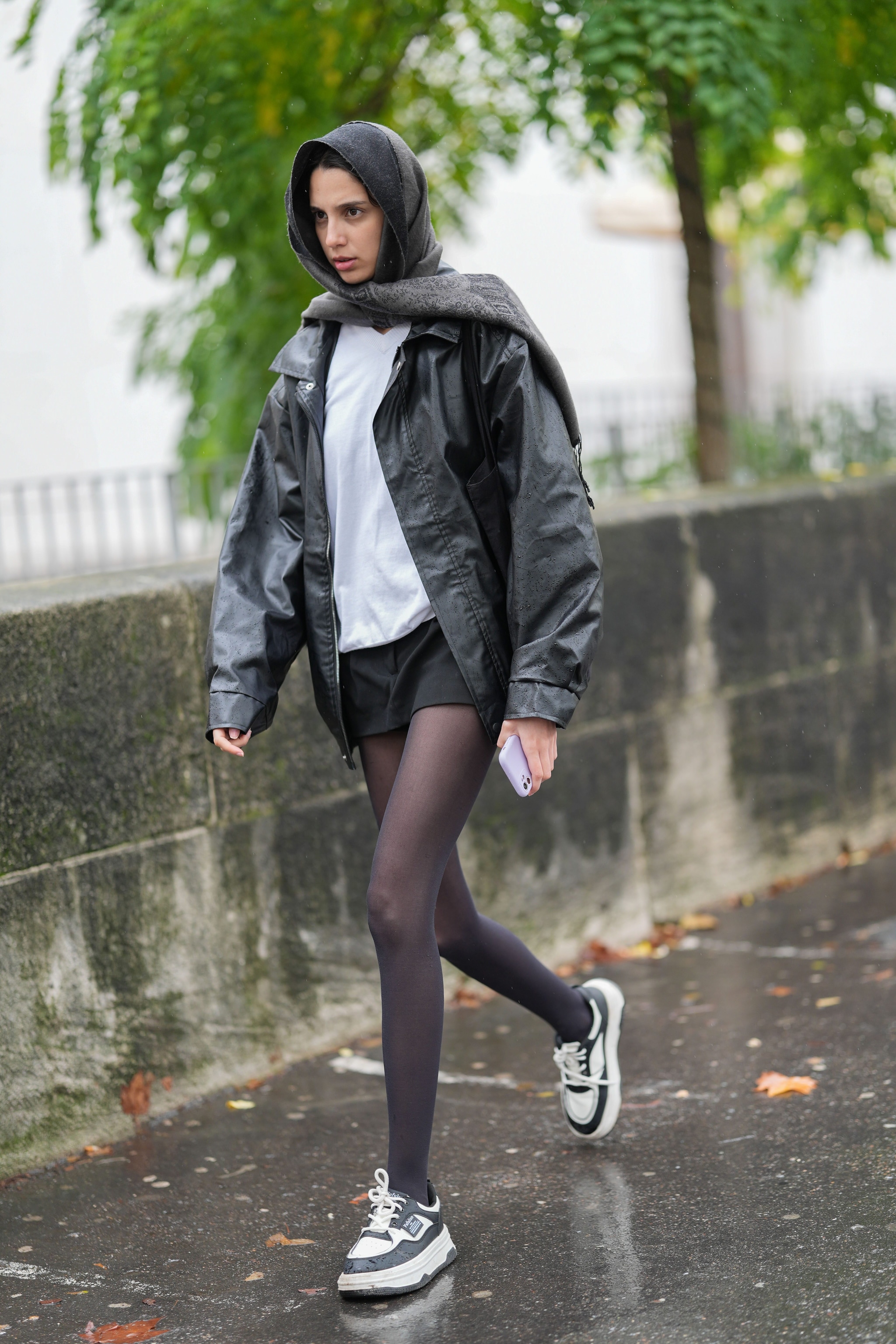 Un look street style con sciarpa utilizzata per ripararsi dalla pioggia