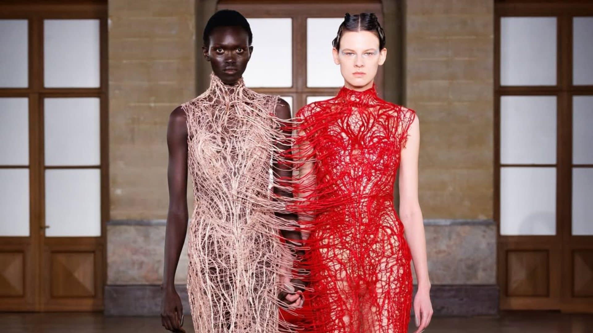 Due modelle coi vestiti attaccati sfilano in passerella mano nella mano: il significato