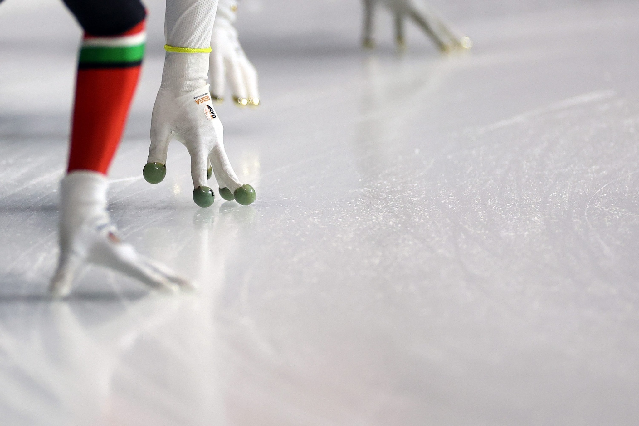 A che servono i "guanti da rana" nello short track e perché ci sono delle sfere sulla punta delle dita