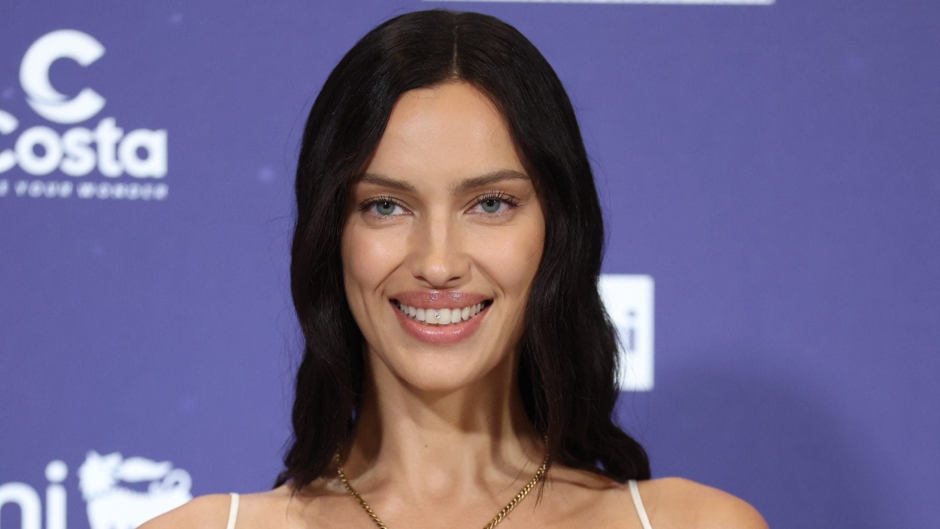 Irina Shayk arriva a Sanremo con un diamante tra i denti: il look "angelico" per la conferenza stampa