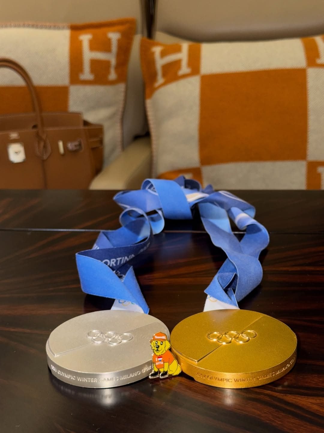 Le medaglie e sullo sfondo la Birkin e i cuscini Hermès