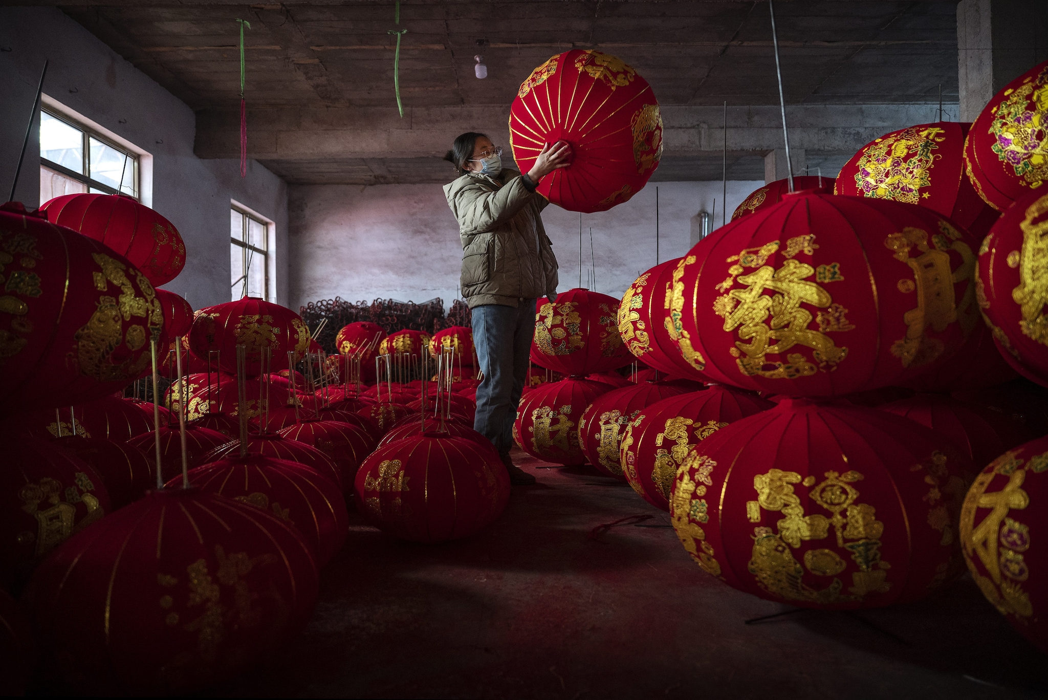 Un’artigiana tra centinaia di lanterne rosse di Tuntou