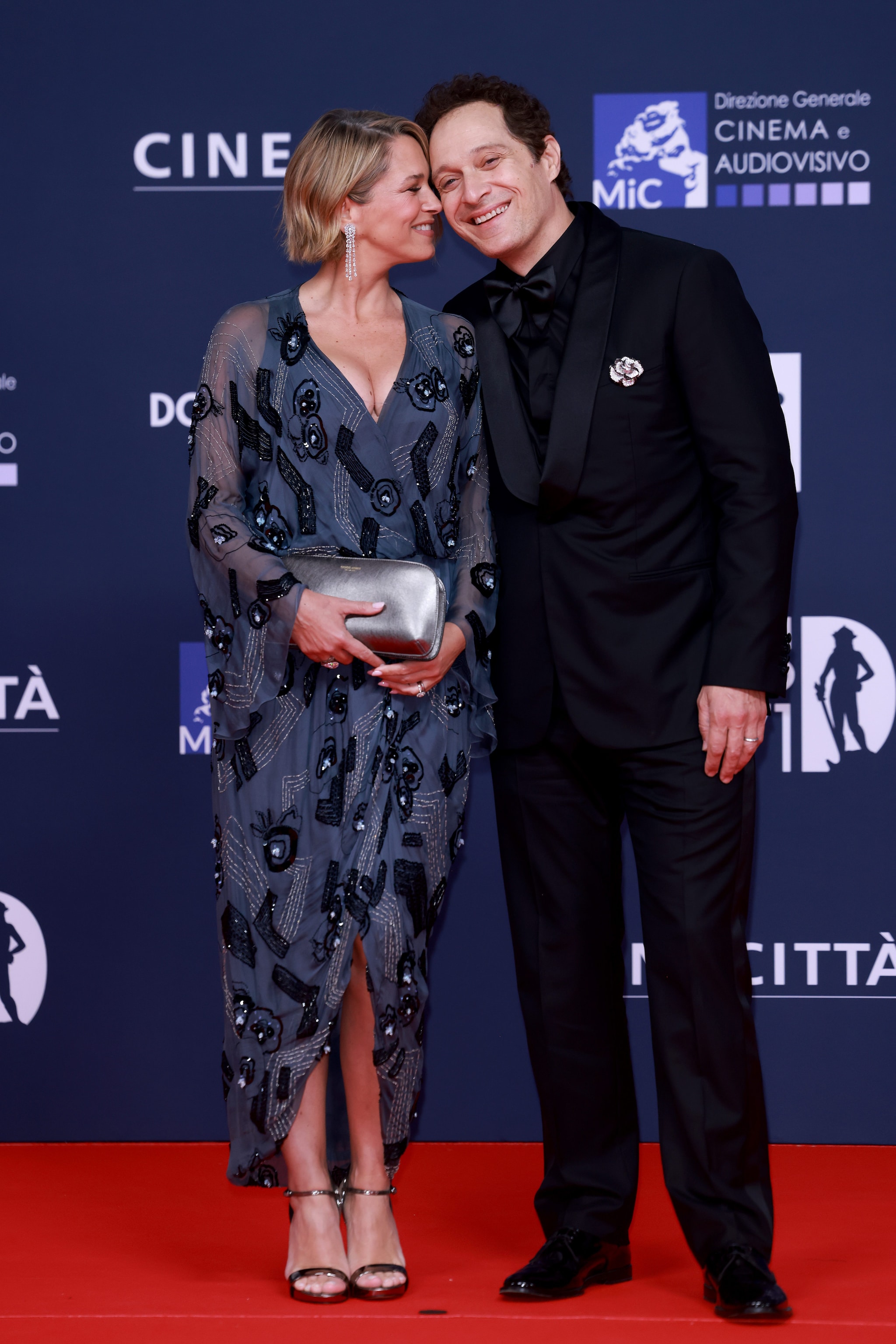 Francesca Barra in Giorgio Armani vintage, Claudio Santamaria in Louis Vuitton