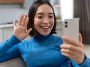 donna-sorridente-del-colpo-medio-con-il-telefono-300x225.jpg