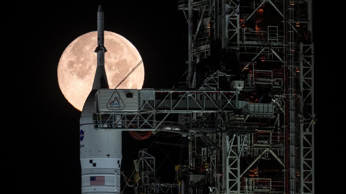 Il razzo lanciatore SLS con la Luna Piena sullo sfondo. Credit: NASA/John Kraus