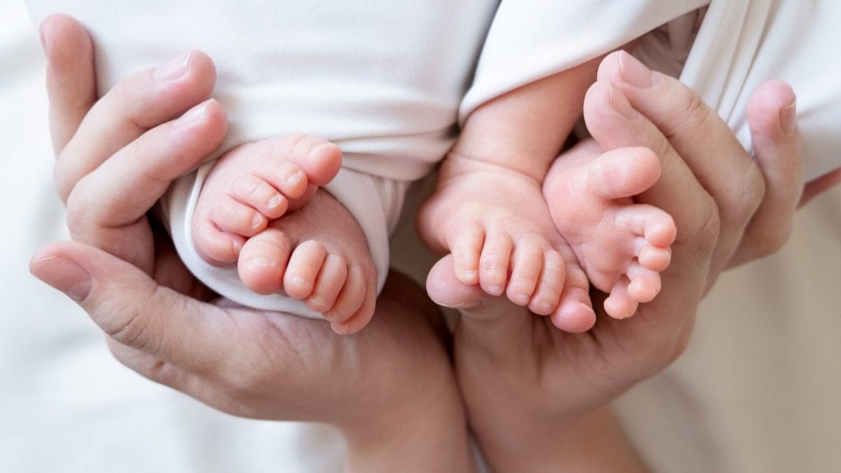 Dettaglio dei piedi di due gemelli neonati, immagine rappresentativa di un raro caso di superfecondazione eteropaternale