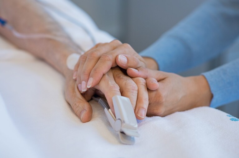 donna stringe la mano di un uomo in ospedale