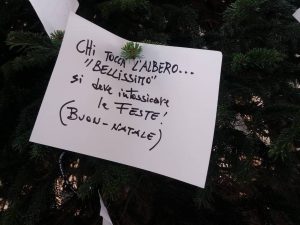 Il cartello con la "maledizione" sulla chioma dell’Albero di Natale in Galleria Umberto.