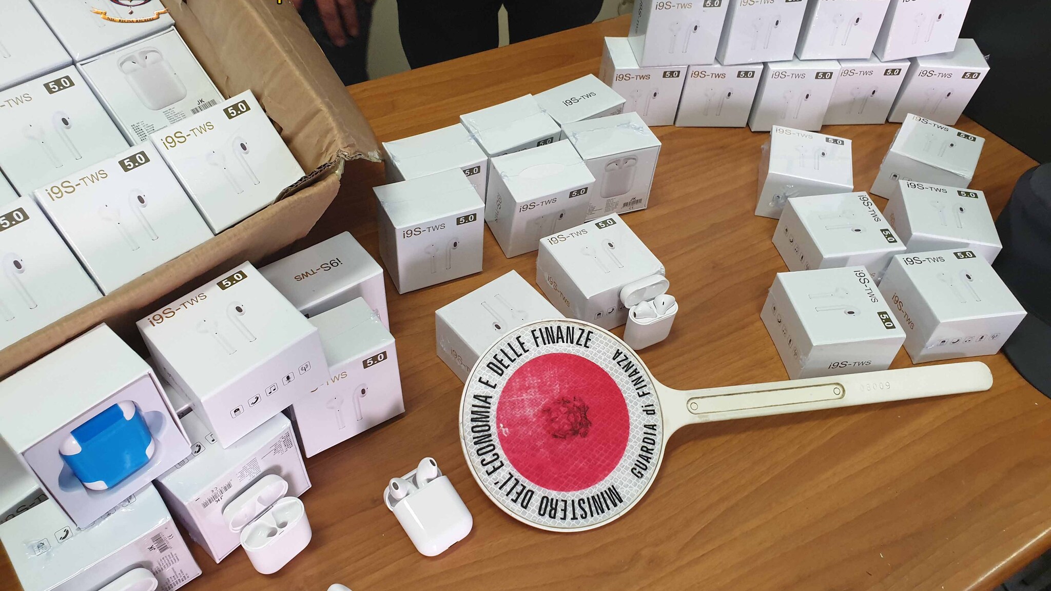 Gli AirPods cinesi, falsi e pericolosi per la salute, sequestrati dalla Guardia di Finanza.