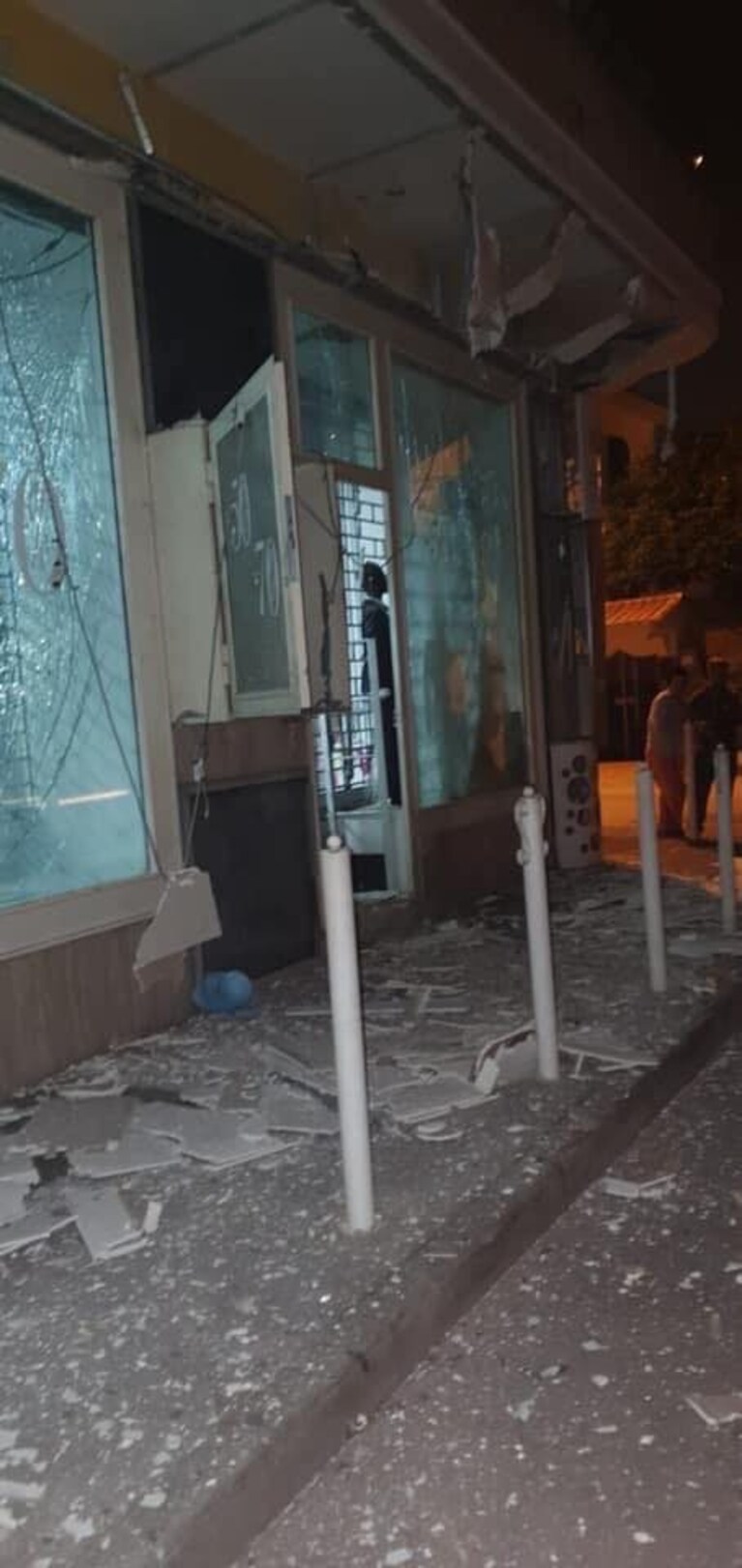 L'esterno del negozio danneggiato dopo l'esplosione della bomba carta.