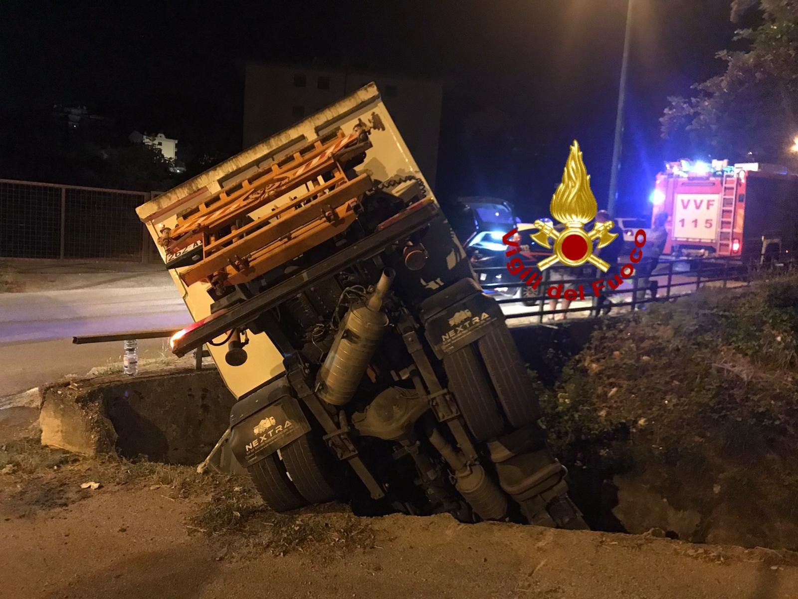 Il camion dei rifiuti finito nel torrente dopo aver sfondato un muretto.
