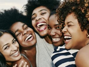 Women laughing together on urban rooftop