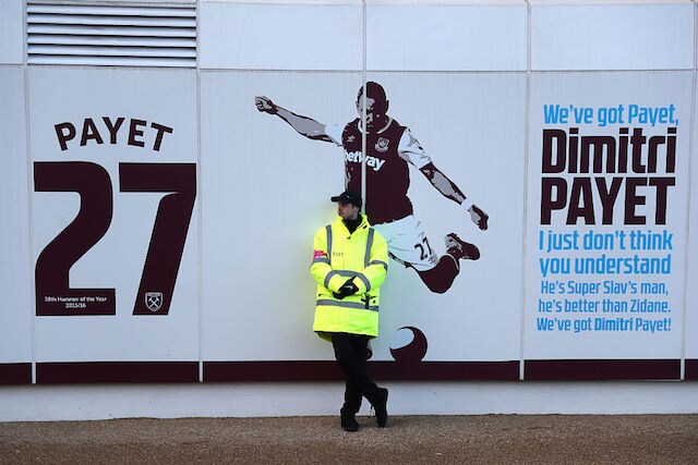 Uno steward controlla la gigantografia dedicata a Payet all'esterno dello stadio